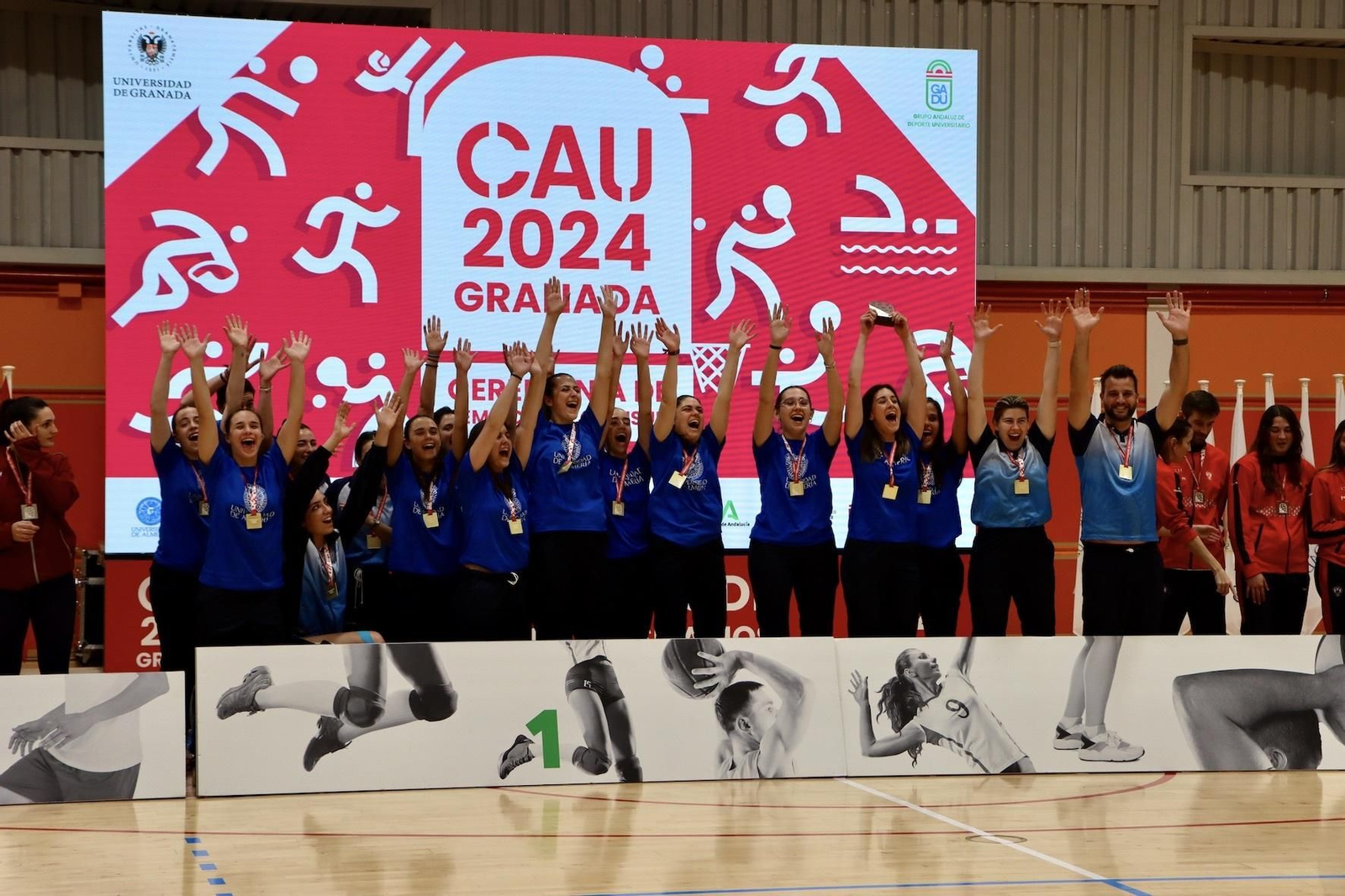 Los componentes del equipo femenino de voleibol reciben el título campeón del CAU.