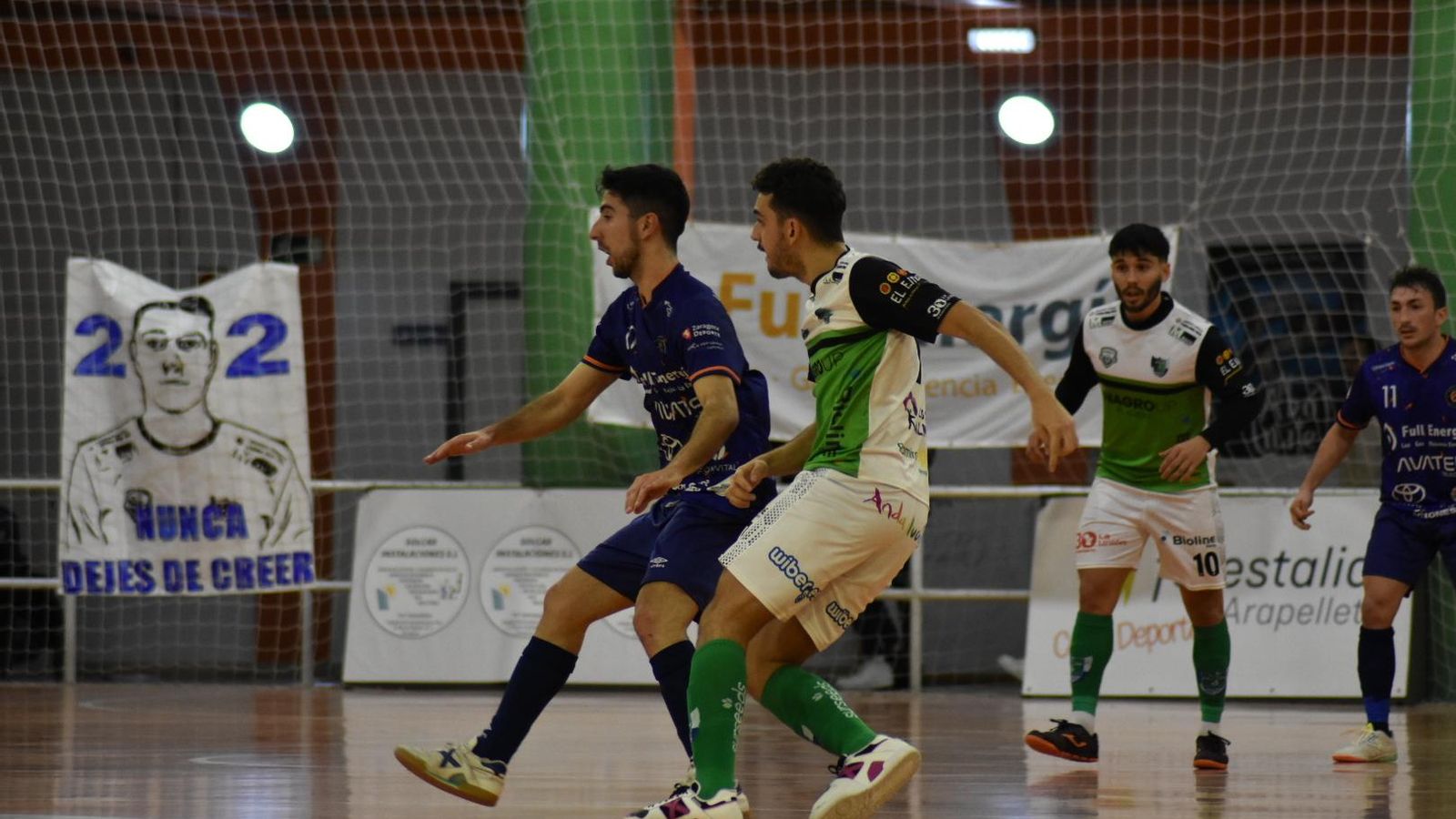 Dos jugadores de ambos equipos se disputan la posición durante un momento del partido.