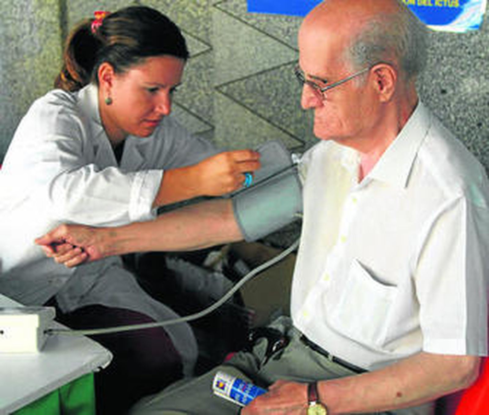 Una trabajadora sanitaria toma la presión arterial a un hombre.