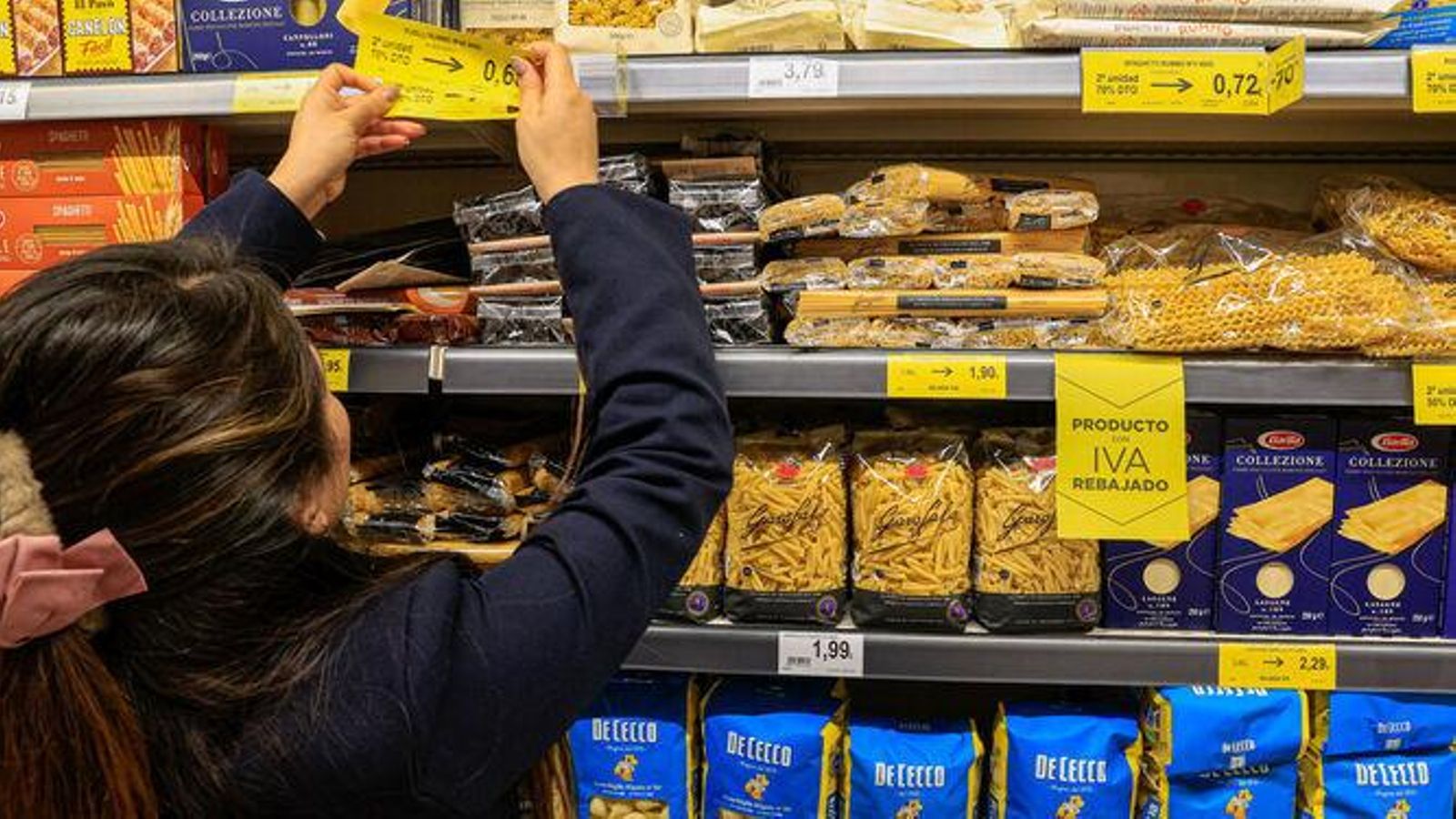 Una dependienta cambia los precios en un supermercado.