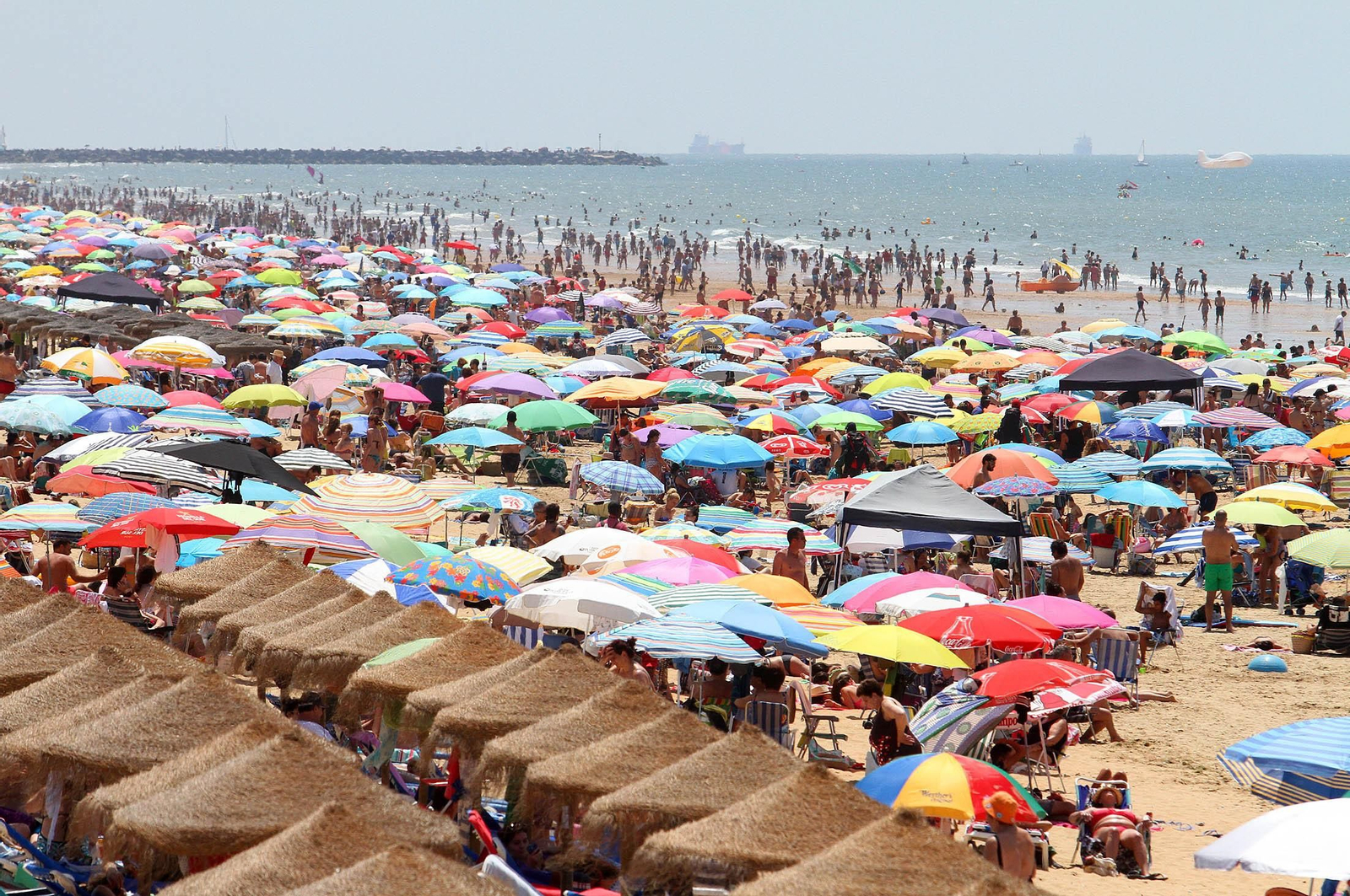 Veraneantes llegando al muelle de Punta Umbría tras bajarse de la canoa.