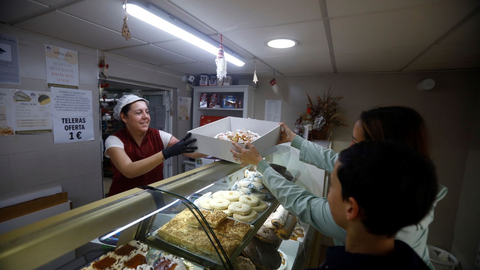 Verónica entrega un roscón de Reyes en la pastelería San Enrique.