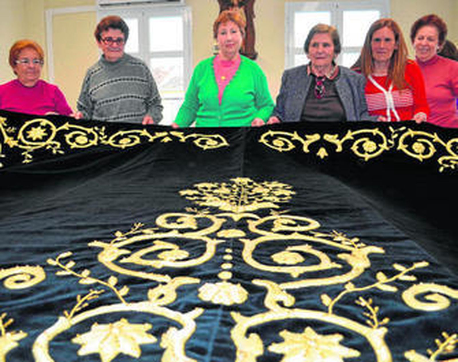 Mujeres del pueblo junto al manto de la Virgen.