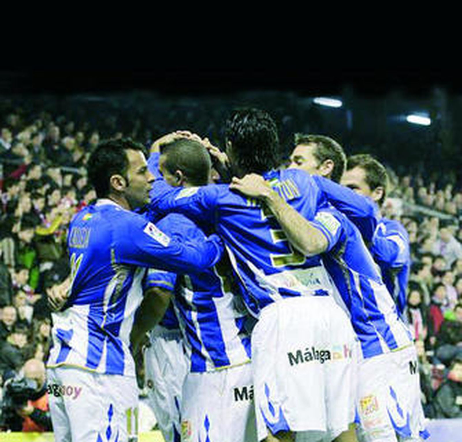 Los jugadores del Málaga se abrazan en una piña para celebrar uno de los goles del sábado en Bilbao.
