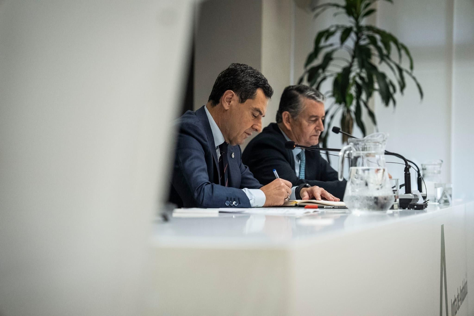 Juanma Moreno y Antonio Sanz tomando notas durante la reunión que han mantenido con la cúpula del SAS.