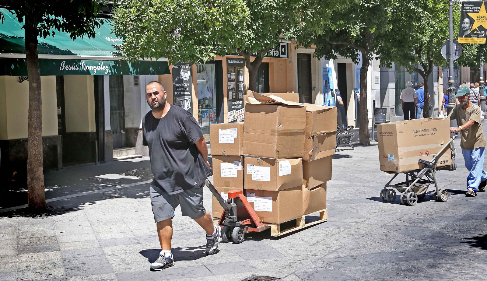 Trabajadores ayer transportan unas cajas por las calles del centro.