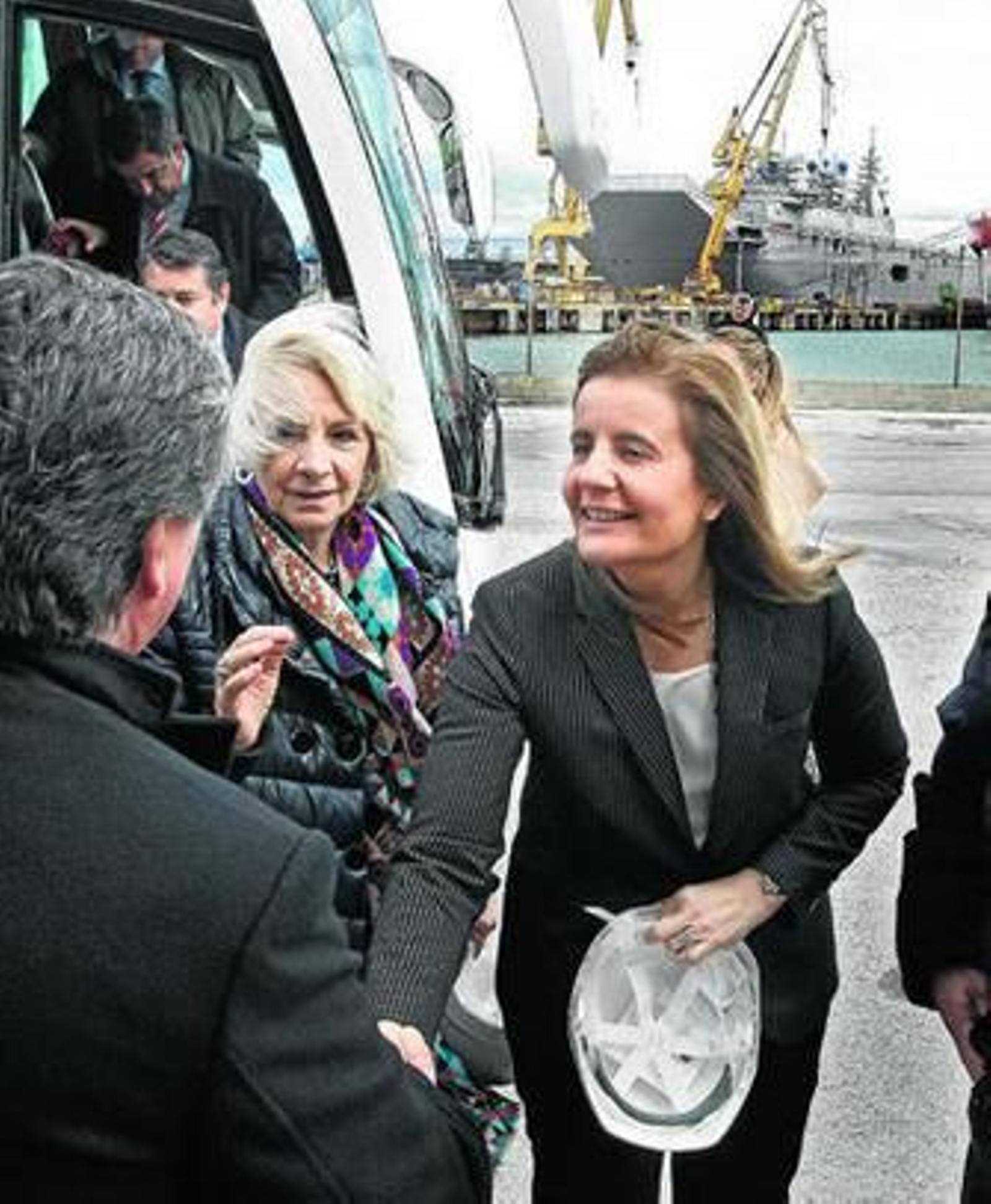 La ministra Fátima Báñez, junto a Teófila Martínez, ayer a su llegada al astillero gaditano, con el 'Juan Carlos I' al fondo.