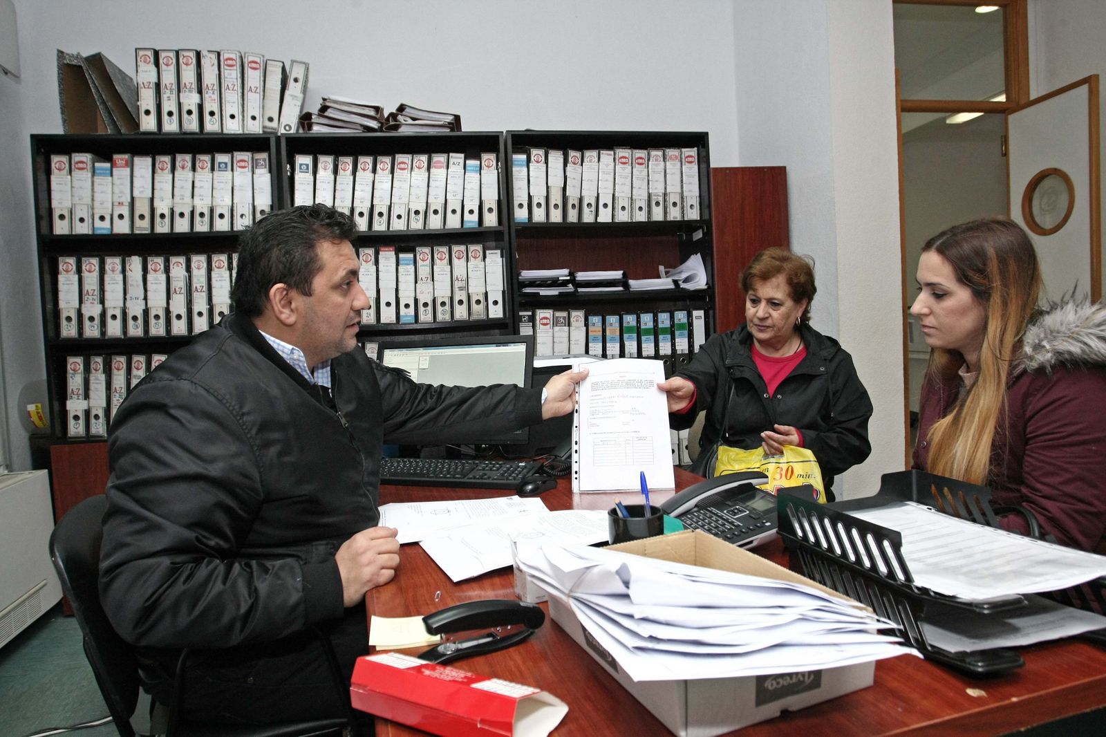 El técnico municipal Bartolomé Heredia atiende a una familia en la oficina de reclamación de daños, ayer por la mañana.