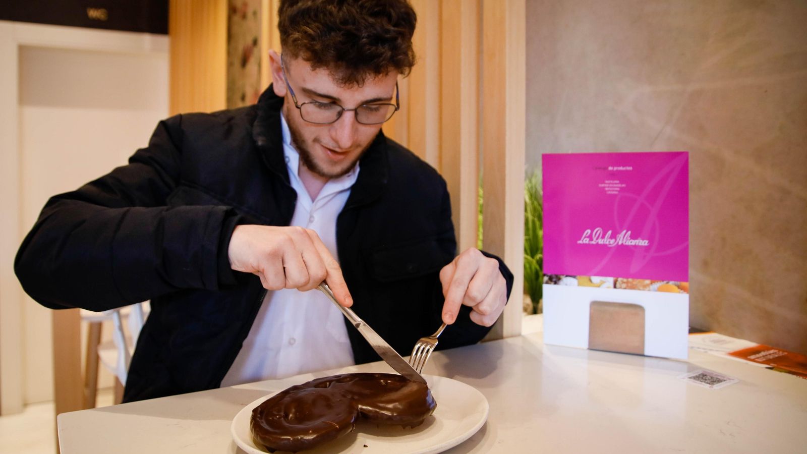 Un joven degusta en La Dulce Alianza una de sus exquisitas palmeritas de chocolate. Un joven degusta en La Dulce Alianza una de sus exquisitas palmeritas de chocolate.
