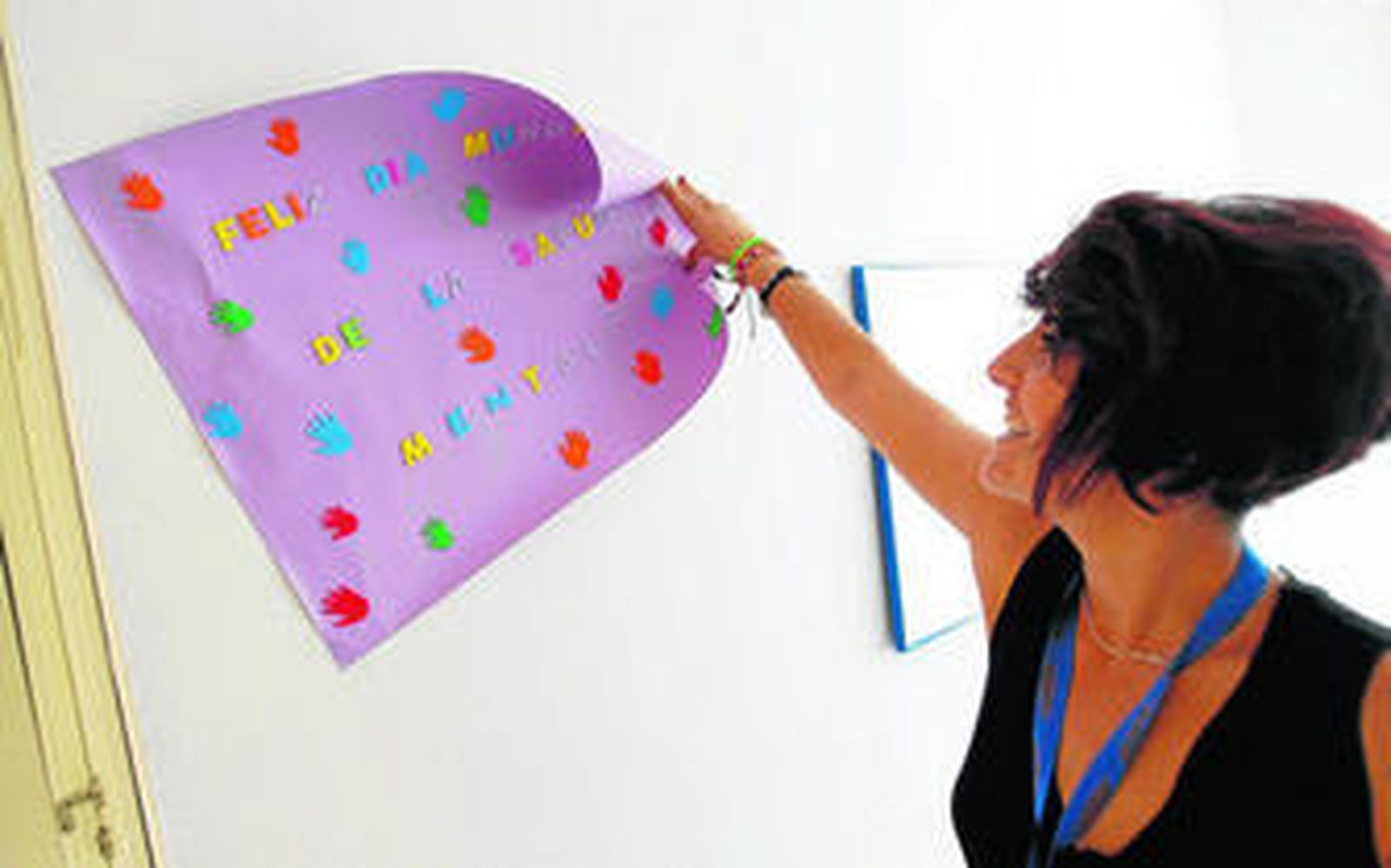 Una de las monitoras de la Casa Hogar sostiene un cartel elaborado por el día de la Salud Mental.