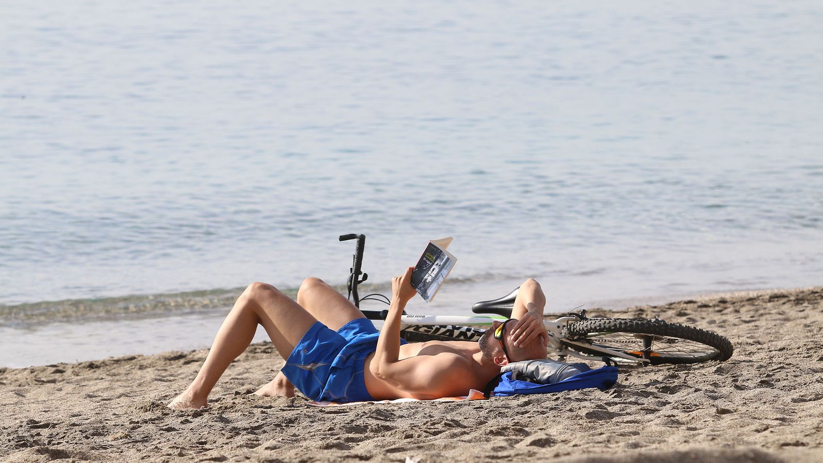 Lectura con bañadora junto a la playa.