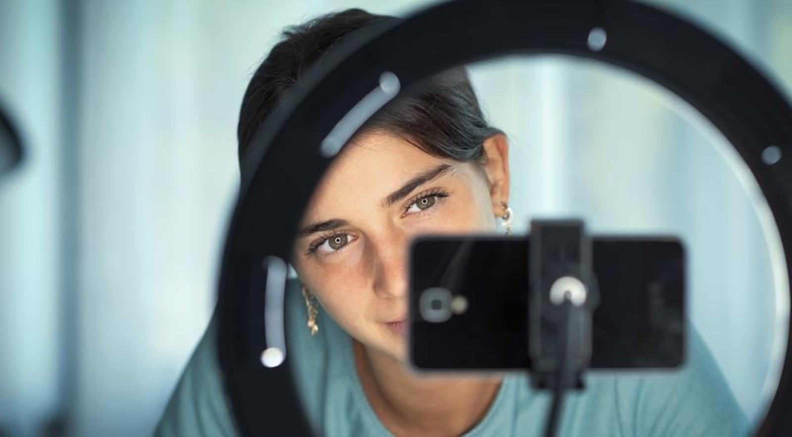 Una joven frente a un teléfono móvil.