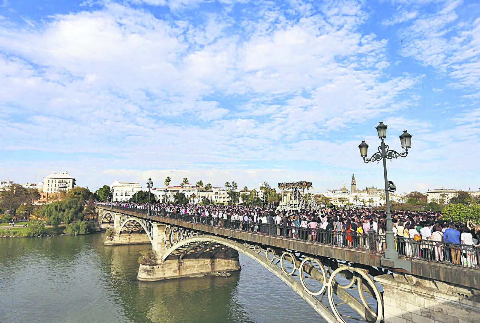 La Virgen de la Estrella cruza el puente de Triana camino de Sevilla en la tarde del Domingo de Ramos.