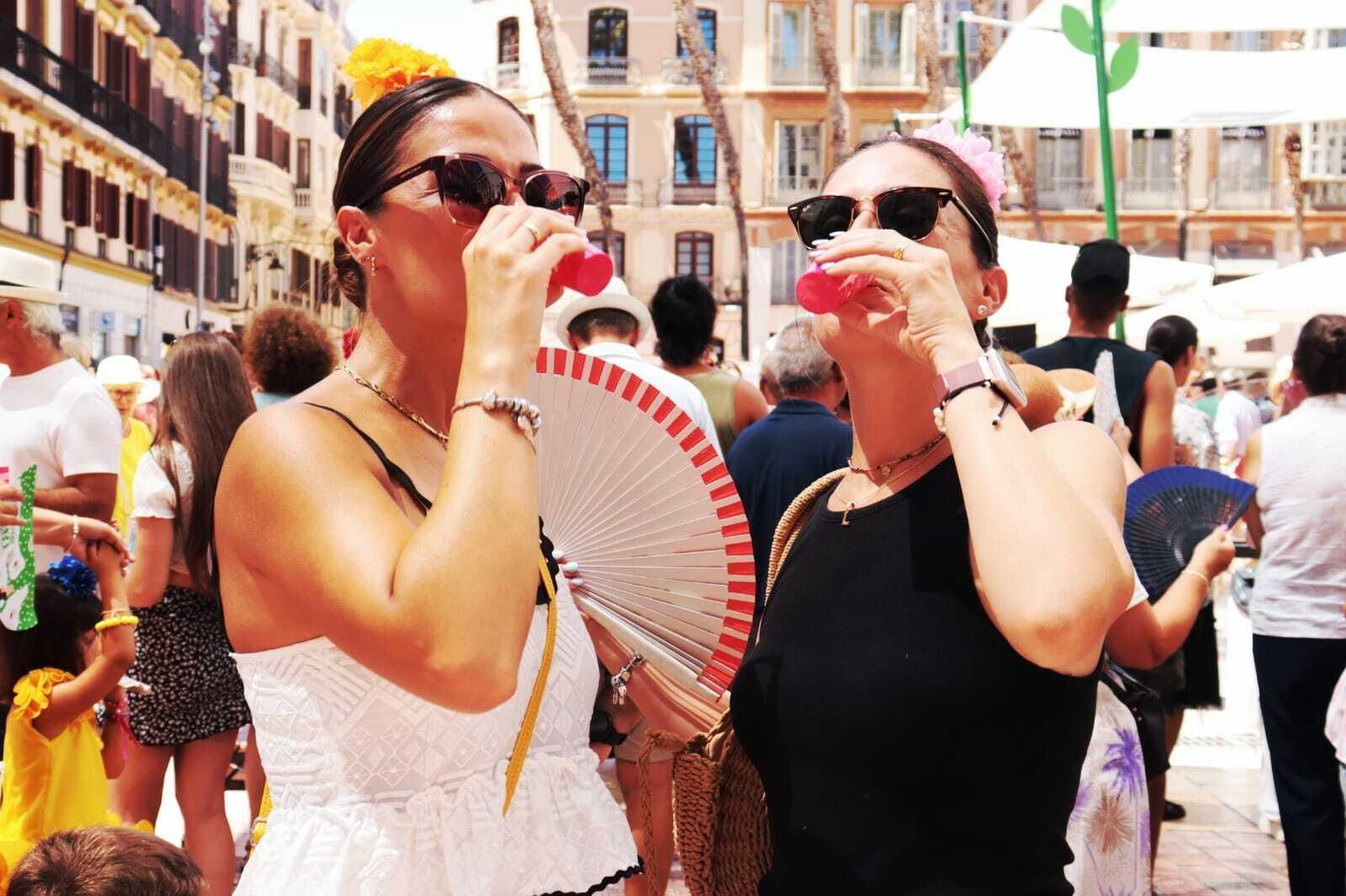 Dos mujeres brindan en la plaza de la Constitución durante la Feria de Málaga.