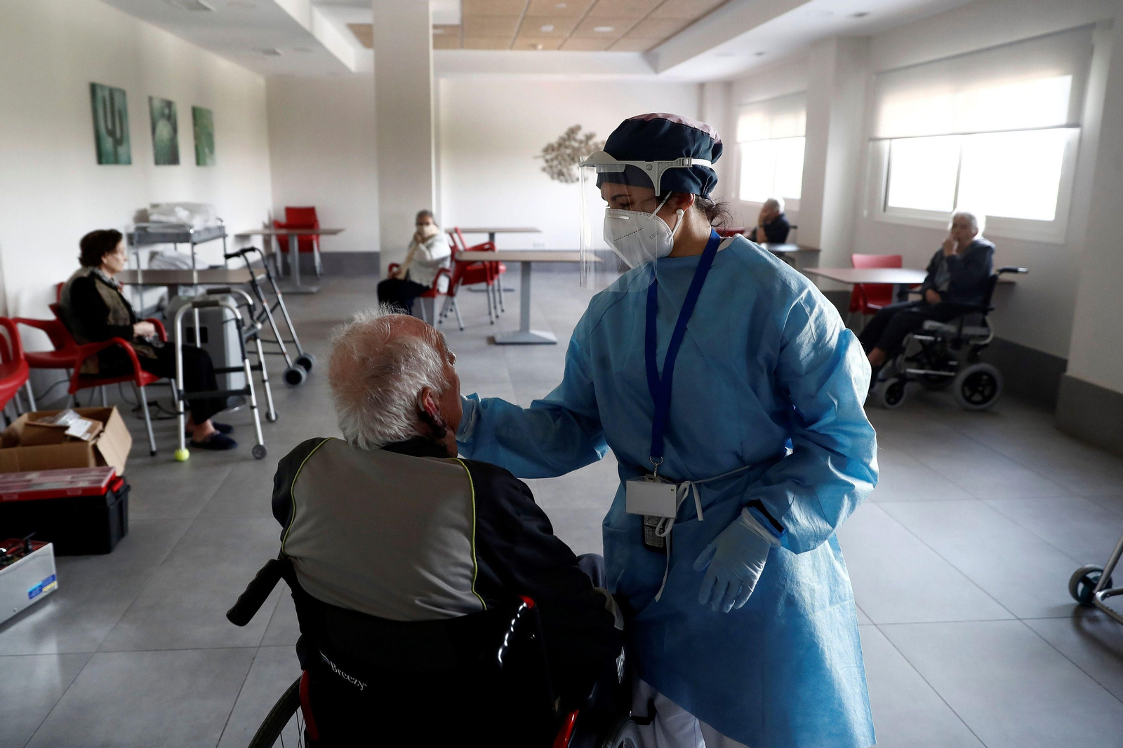 Un anciano atendido por una enfermera en una residencia.