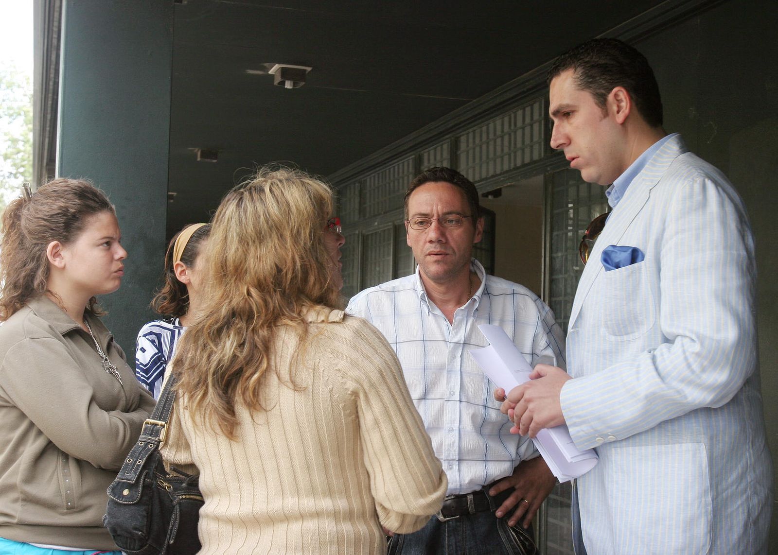 El abogado Pedro J. Pérez, a la derecha, atendiendo a unos clientes ante las puertas de los Juzgados.