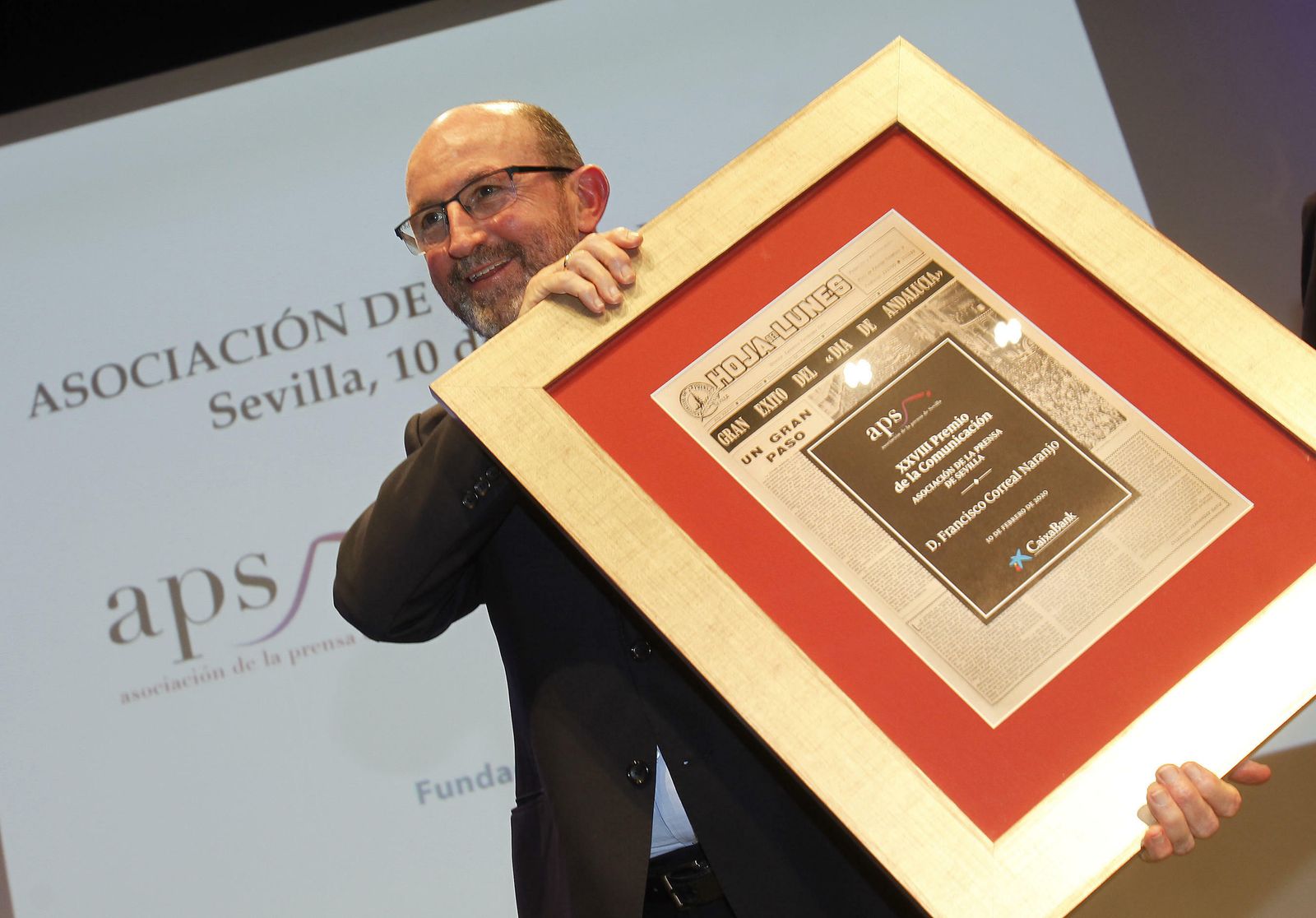 Francisco Correal sonríe y muestra el galardón de la Asociación de la Prensa de Sevilla.