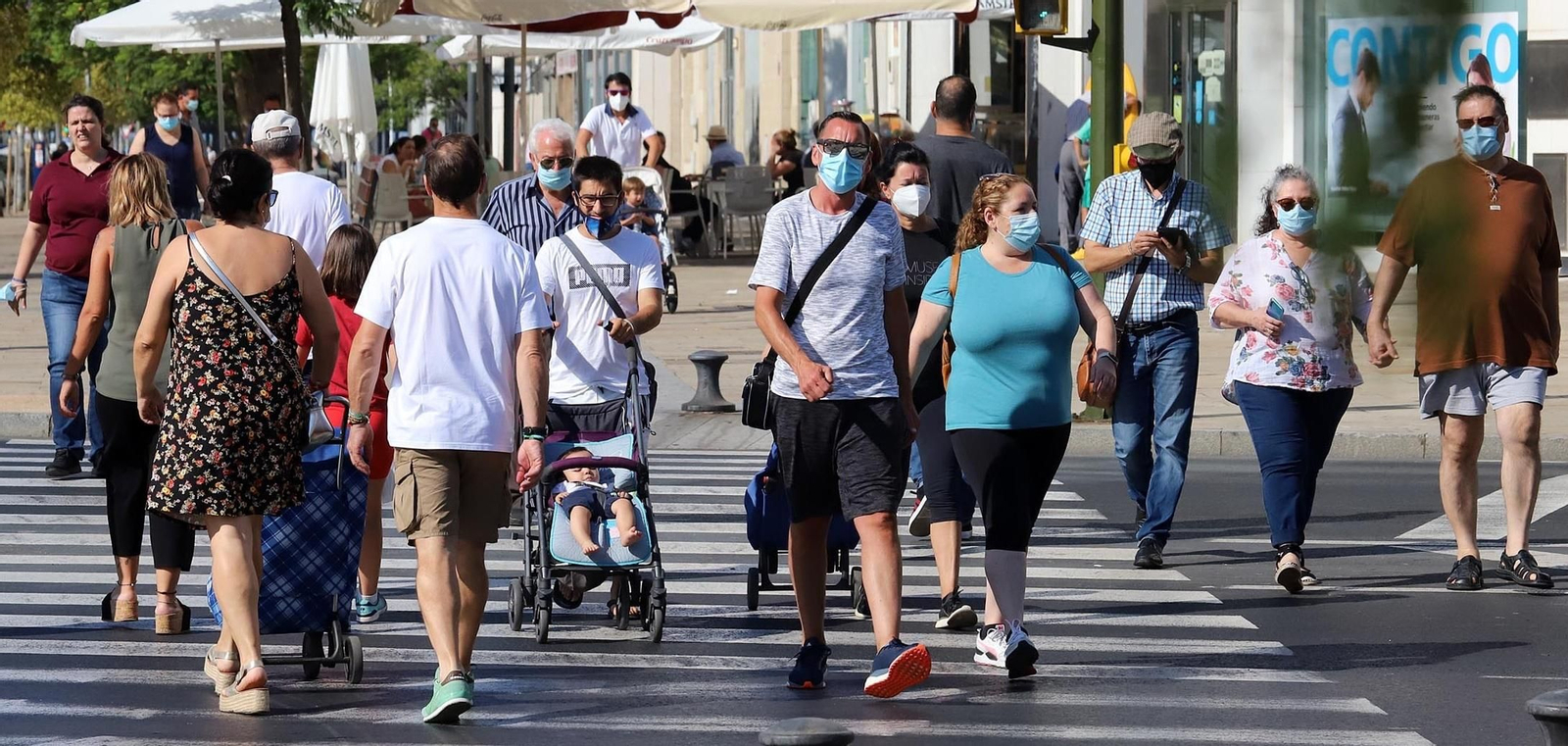 Varias personas pasean protegidas con mascarillas.
