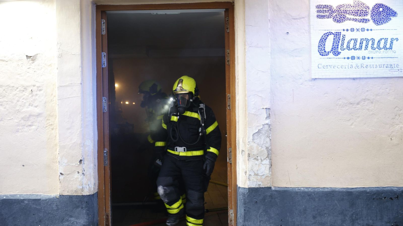 Uno de los bomberos, saliendo del establecimiento donde se registró el incendio.
