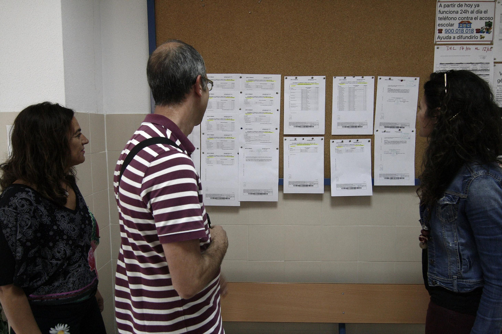 Una familia mira las listas en el proceso de escolarización