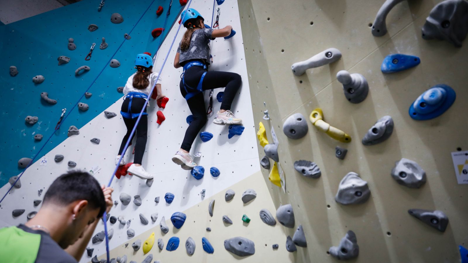 Dos niñas practican escalada en un rocódromo tras la presentación de los Juegos Deportivos Provinciales.