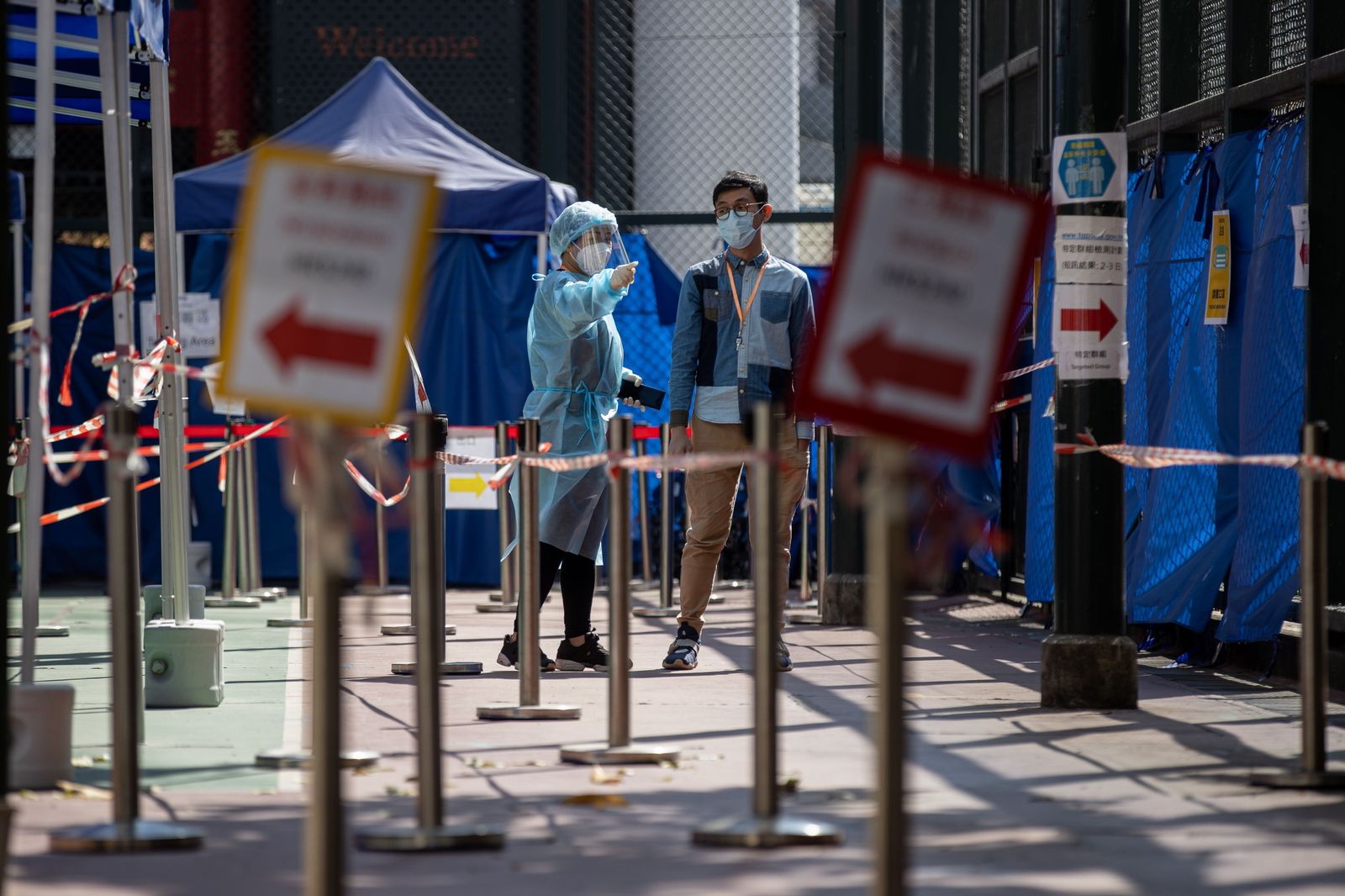 Una sanitaria indica la entrada a un centro de test de coronavirus en Hong Kong.