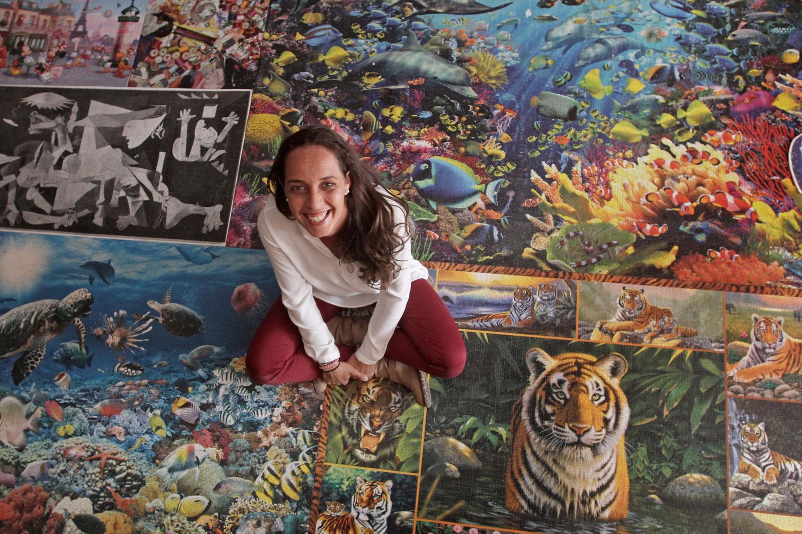 La algecireña Demelza Becerra, sentada sobre rompecabezas, en su propia casa.