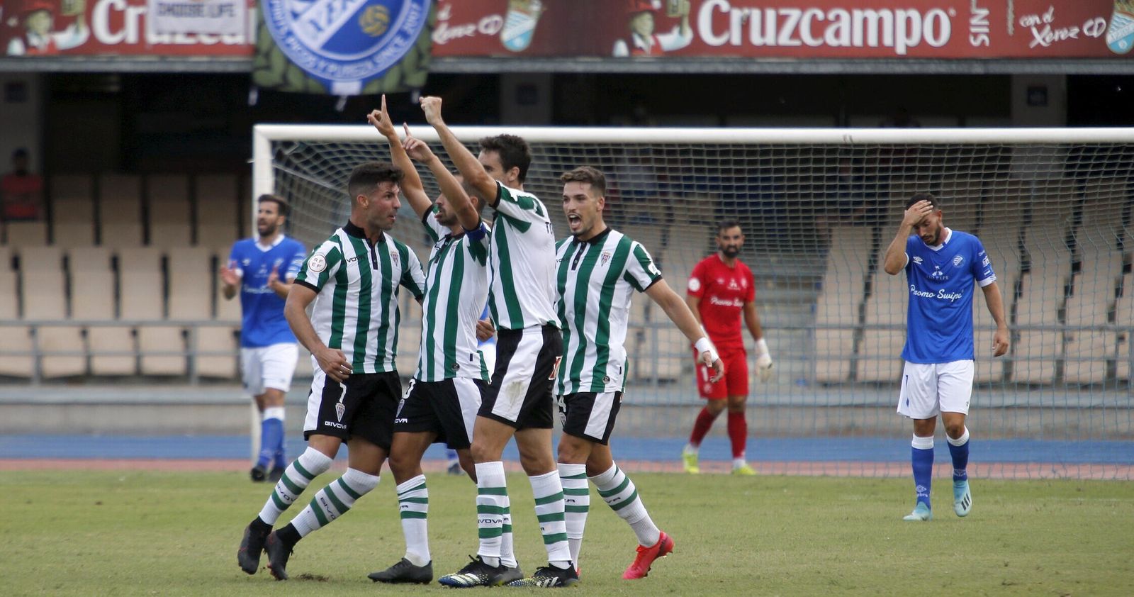 Willy y Toni Arranz abrazan a De las Cuevas, con José Alonso tras ellos, en la celebración de un gol en Chapín.