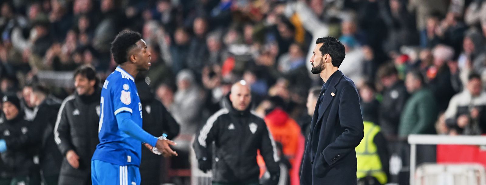 Vinícius se dirige al banquillo mientras Arbeloa mira con pesar lo que está sucediendo.