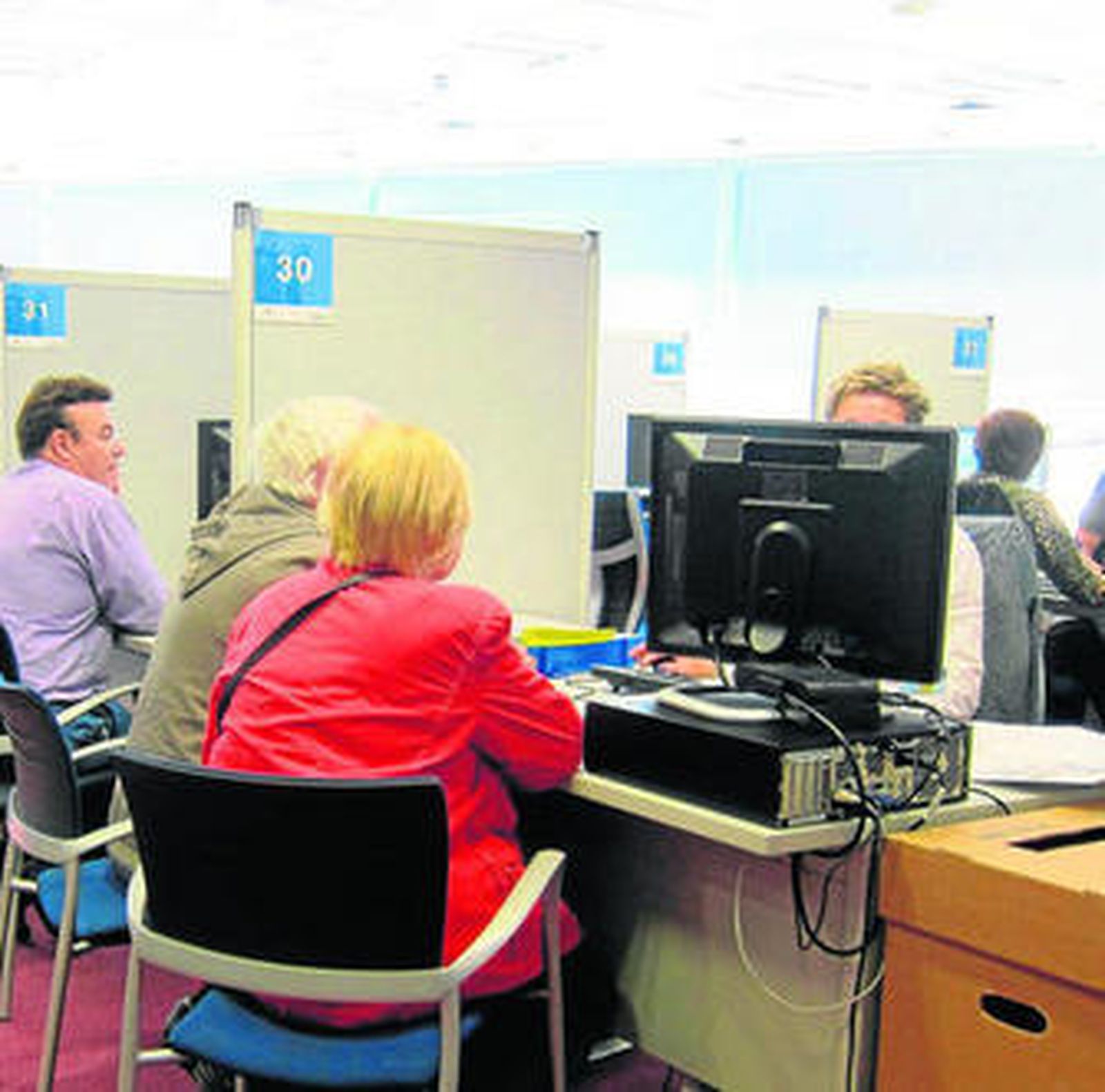 Varias personas presentan la declaración de la renta en una oficina de Hacienda.