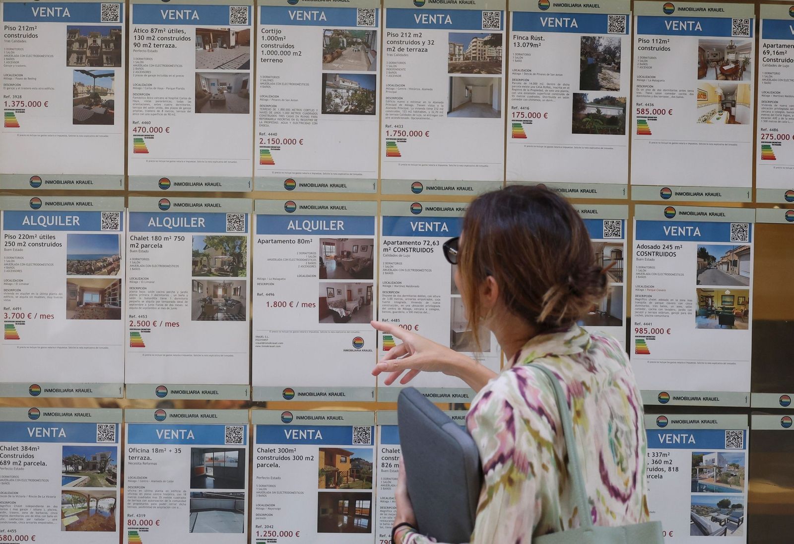 Una mujer mira carteles de anuncios de vivienda en Málaga