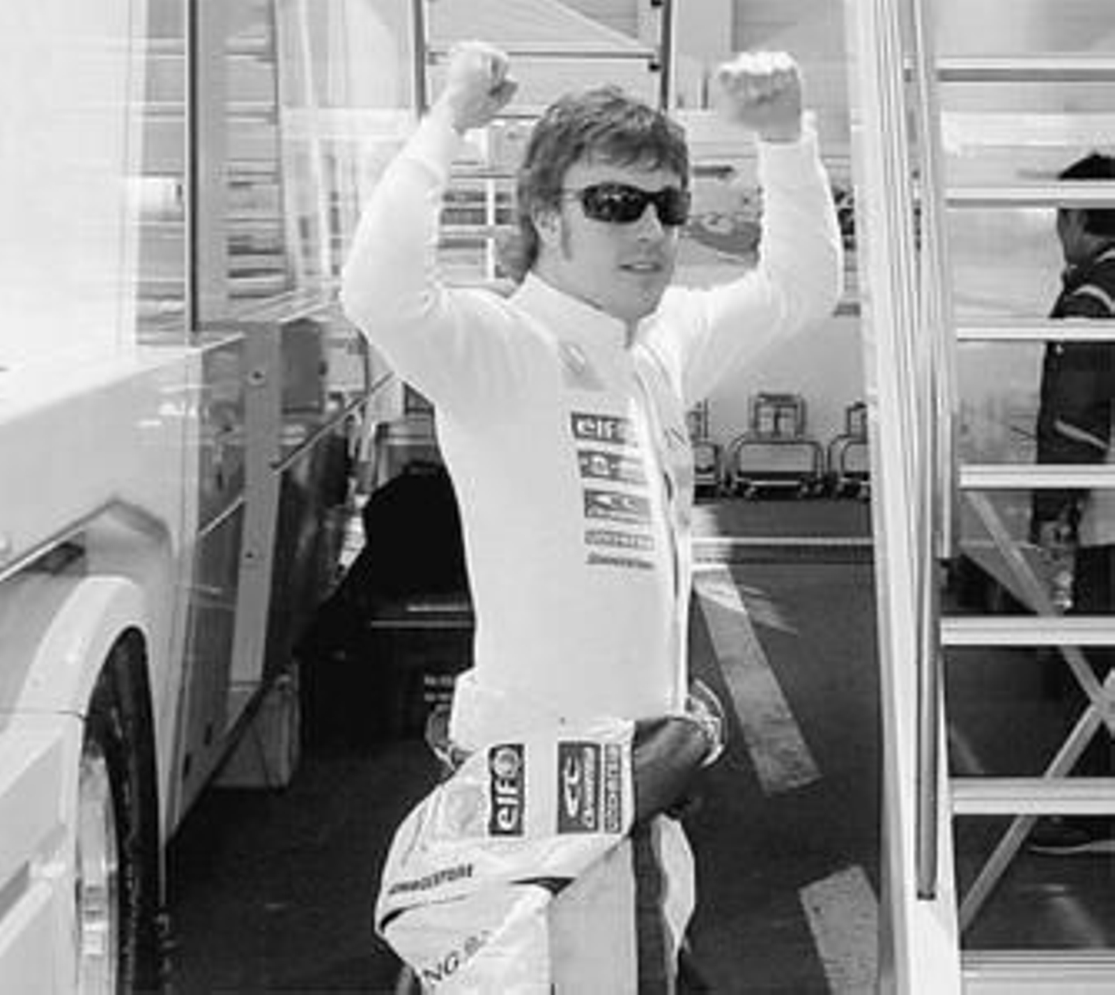 Fernando Alonso hace la señal del triunfo en el 'paddock'.