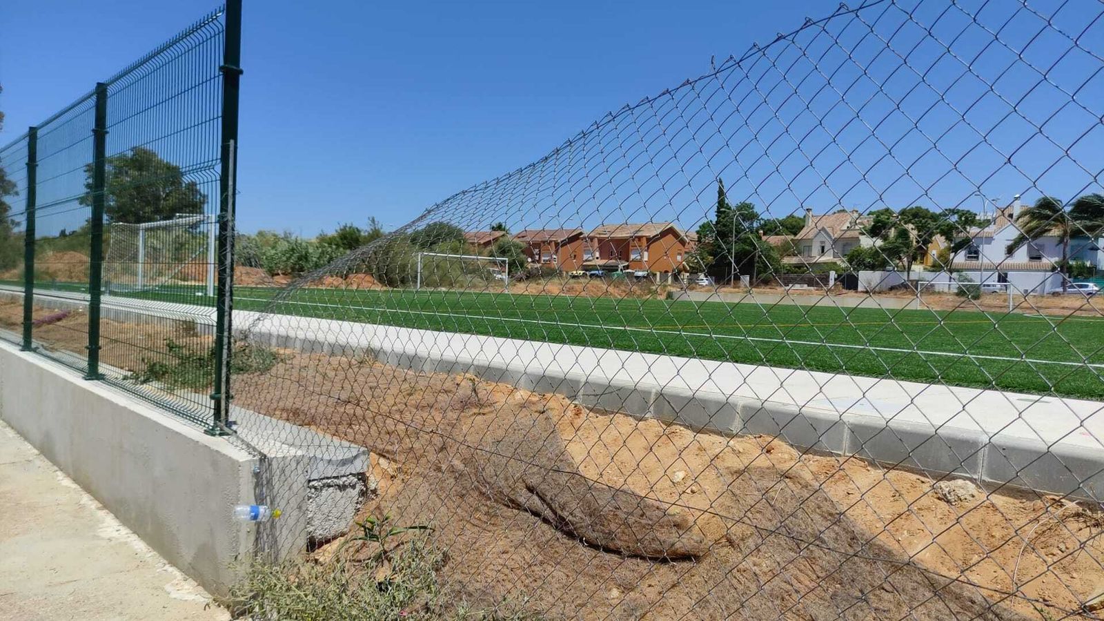Una imagen del nuevo campo de fútbol de El Águila, con la valla dañada por las personas que se cuelan en el recinto.