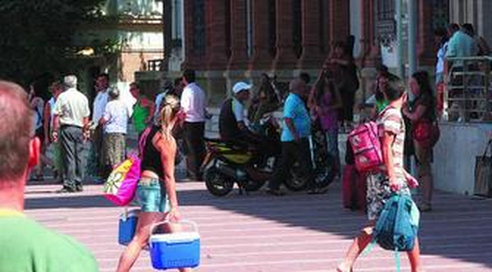 Adolescentes con neveras y mochilas yendo hacia la estación de tren.