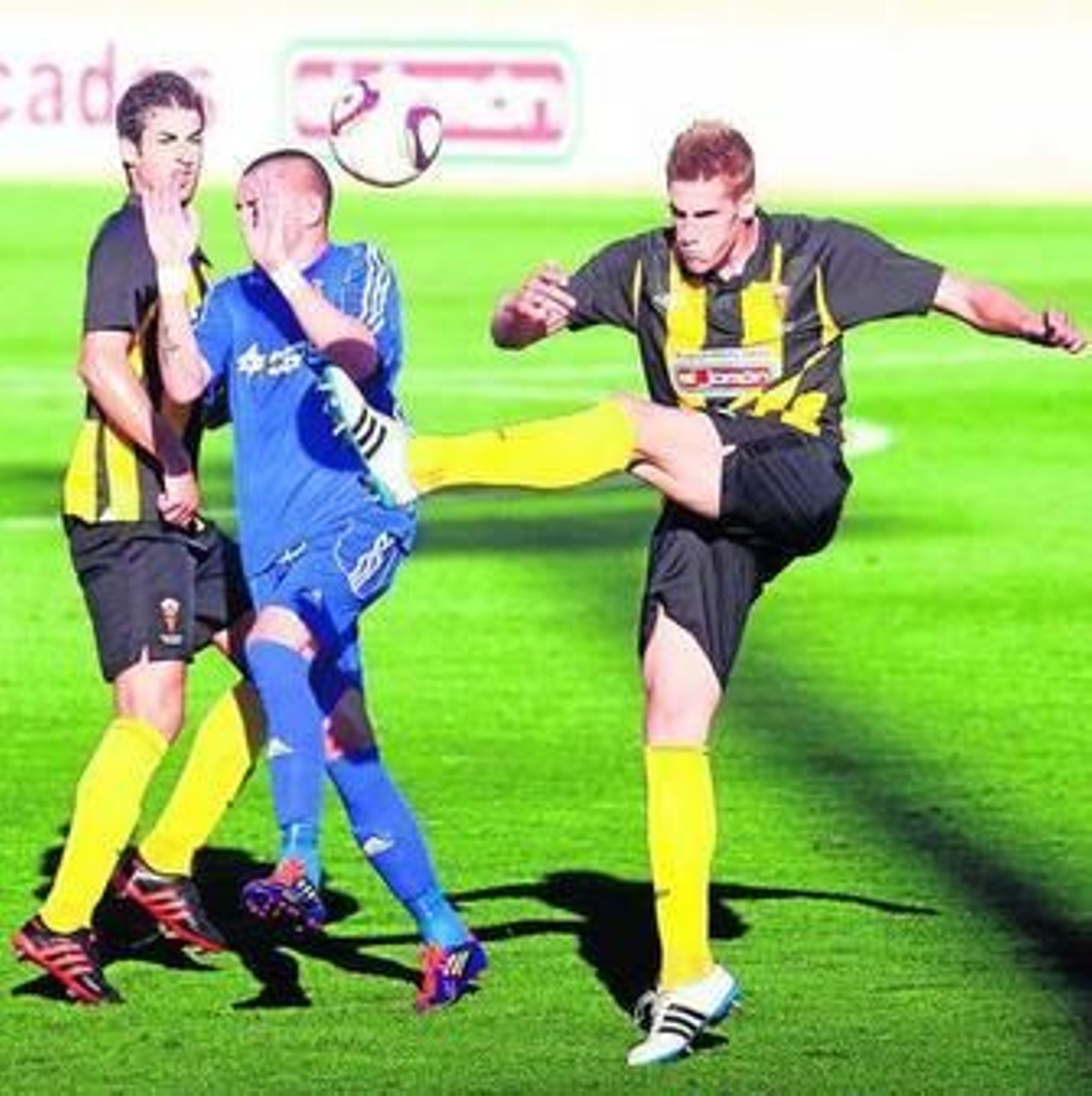 Dos jugadores del San Roque rodean al delantero balono Copi, el sábado en Lepe.