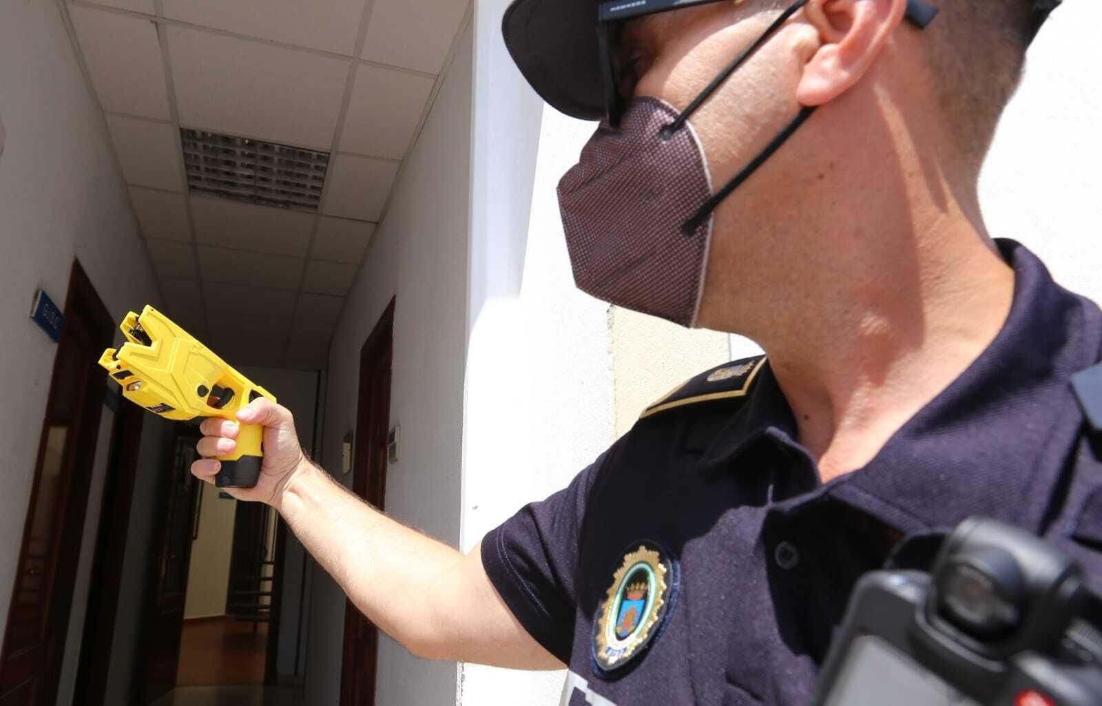 Un agente de Chiclana muestra la pistola Taser.