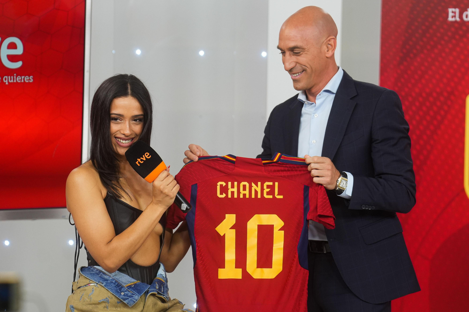Luis Rubiales sonríe mientras entrega a Chanel una camiseta de la selección española.