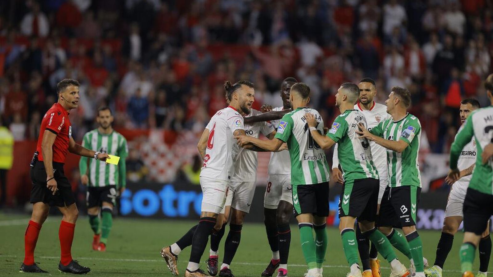 Gil Manzano, amarilla en la mano, observa el agarre entre los jugadores.