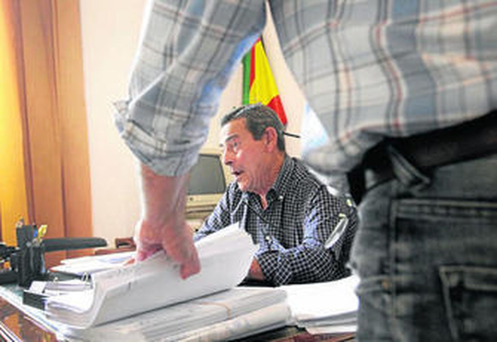 El juez de Paz de Bormujos, en su despacho, flanqueado por el secretario.