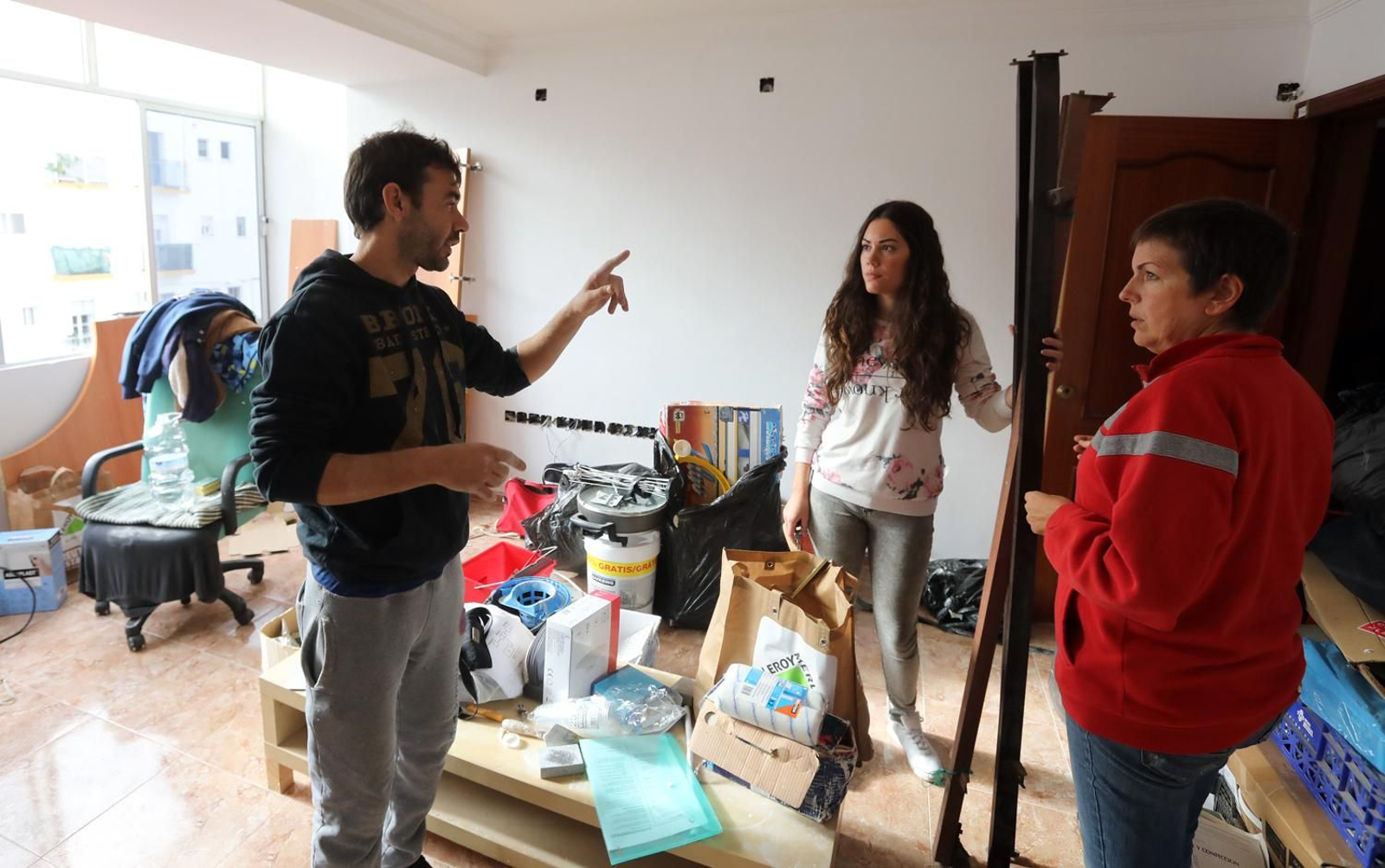 Victoria Sánchez y la trabajadora social atienden las explicaciones del jefe de obra, usuario de la asociación.