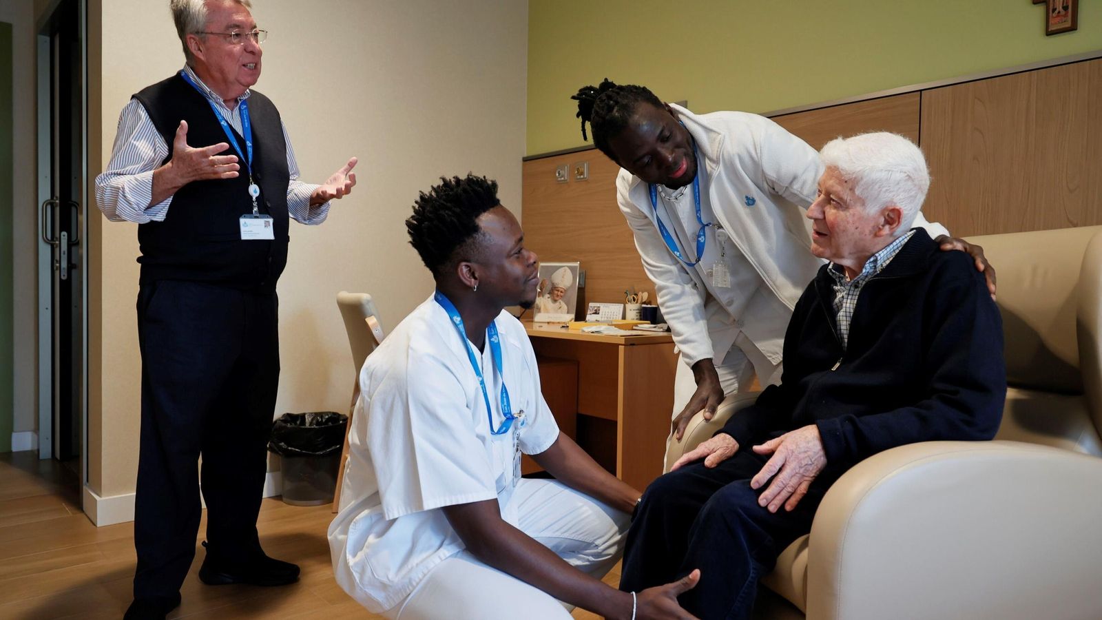 Los jóvenes, junto a un paciente en el área socionaitaria, en compañía del hermano superior de la Orden hospitalaria en Sevilla, Guillermo García.