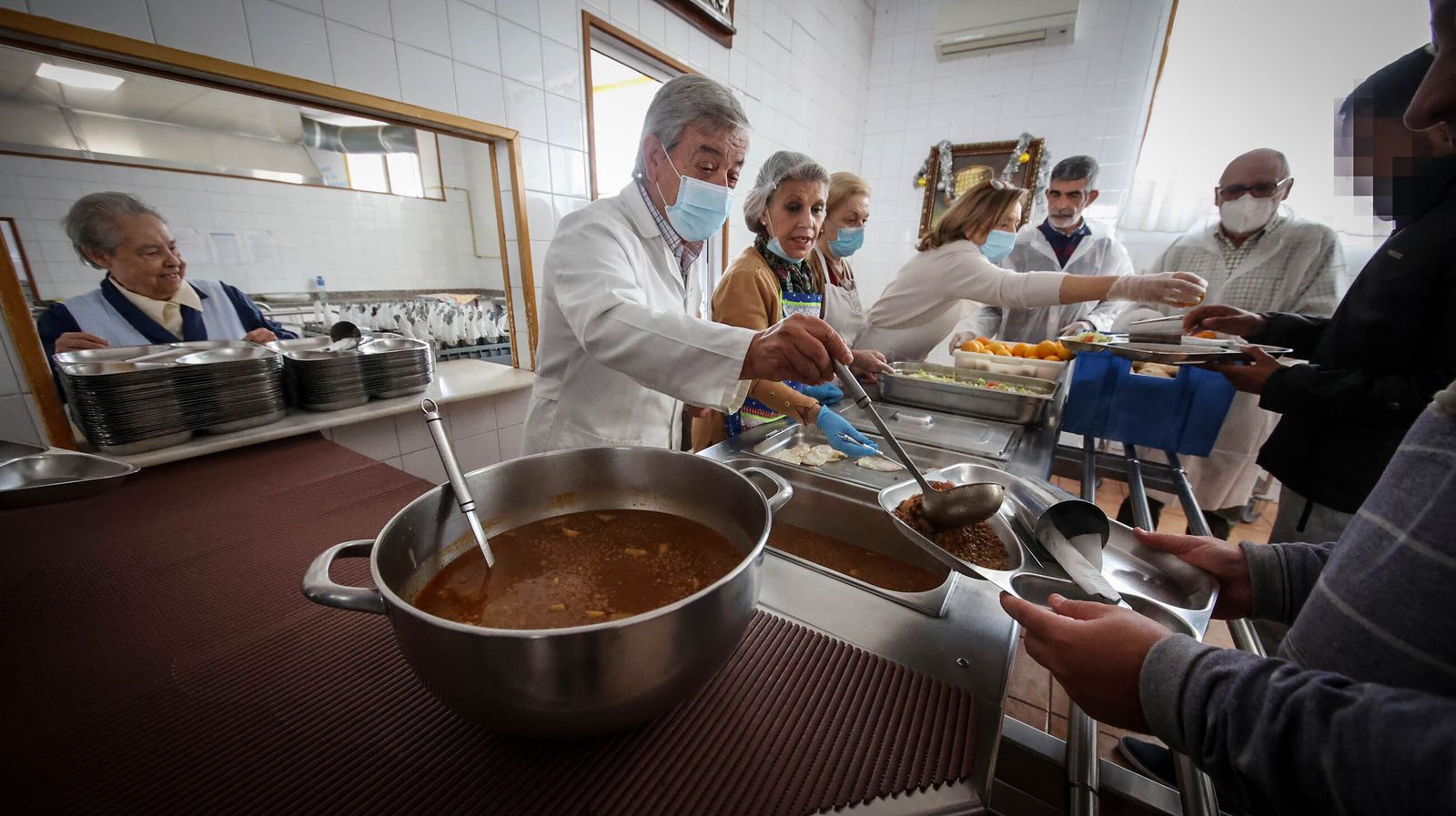 Imagen de los voluntarios del comedor de El Salvador repartiendo la comida entre los usuarios.