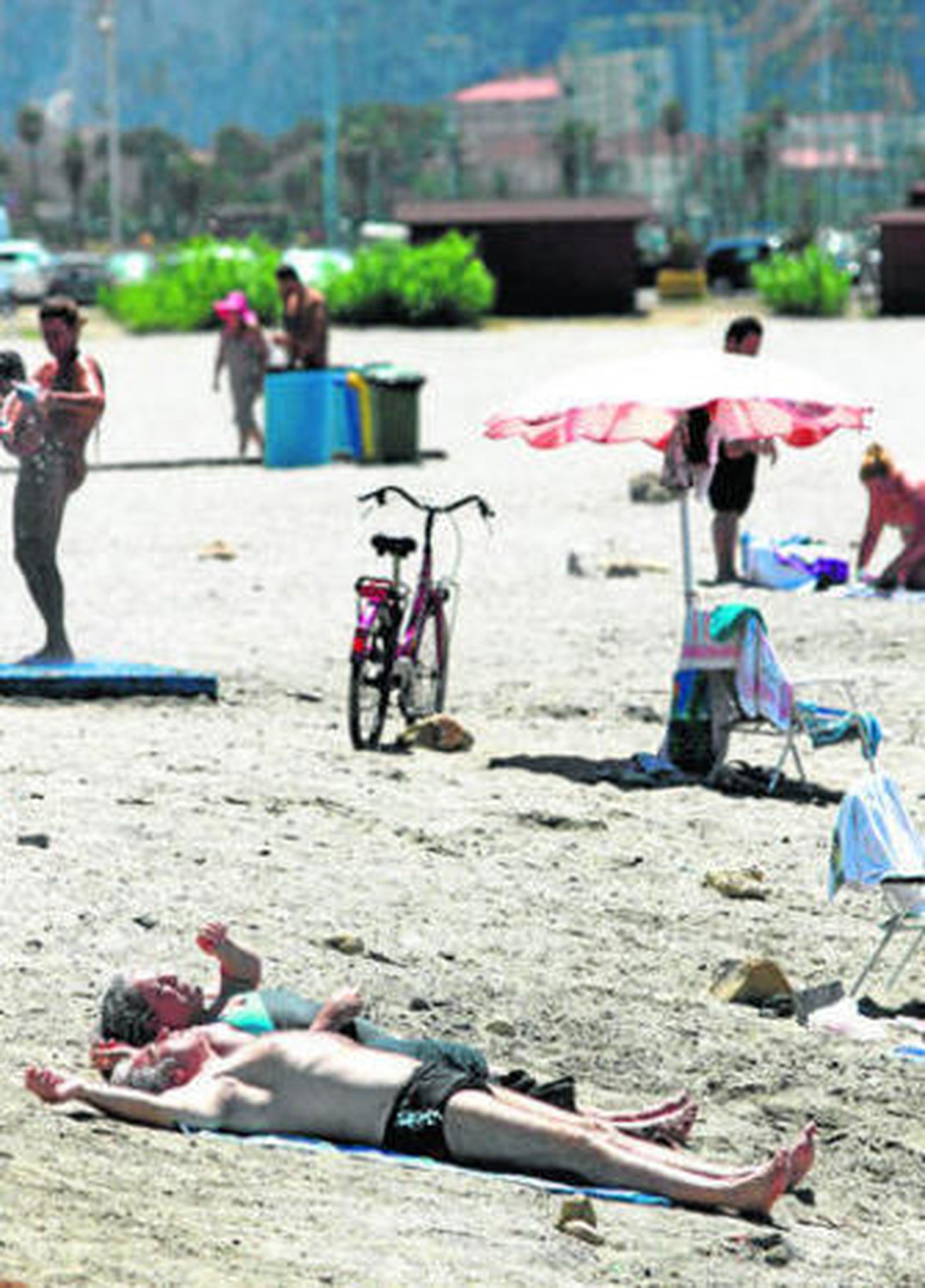Dos usuarios toman el sol en una de las playas de La Línea.