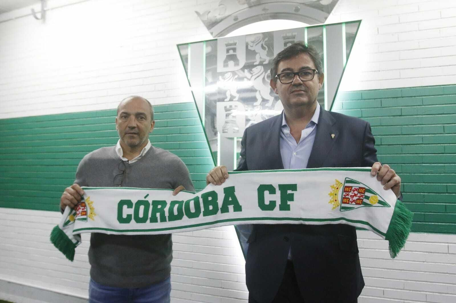 Juan Sabas y Javier González Calvo posan con una bufanda ante el escudo del Córdoba CF.