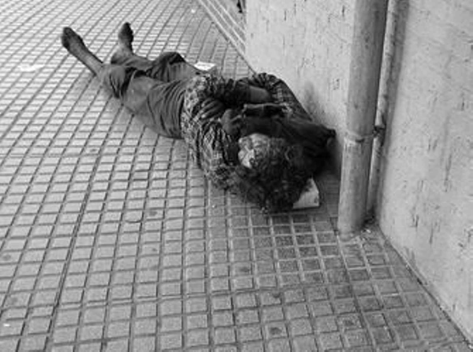 Una persona durmiendo en la calle, en pleno día.