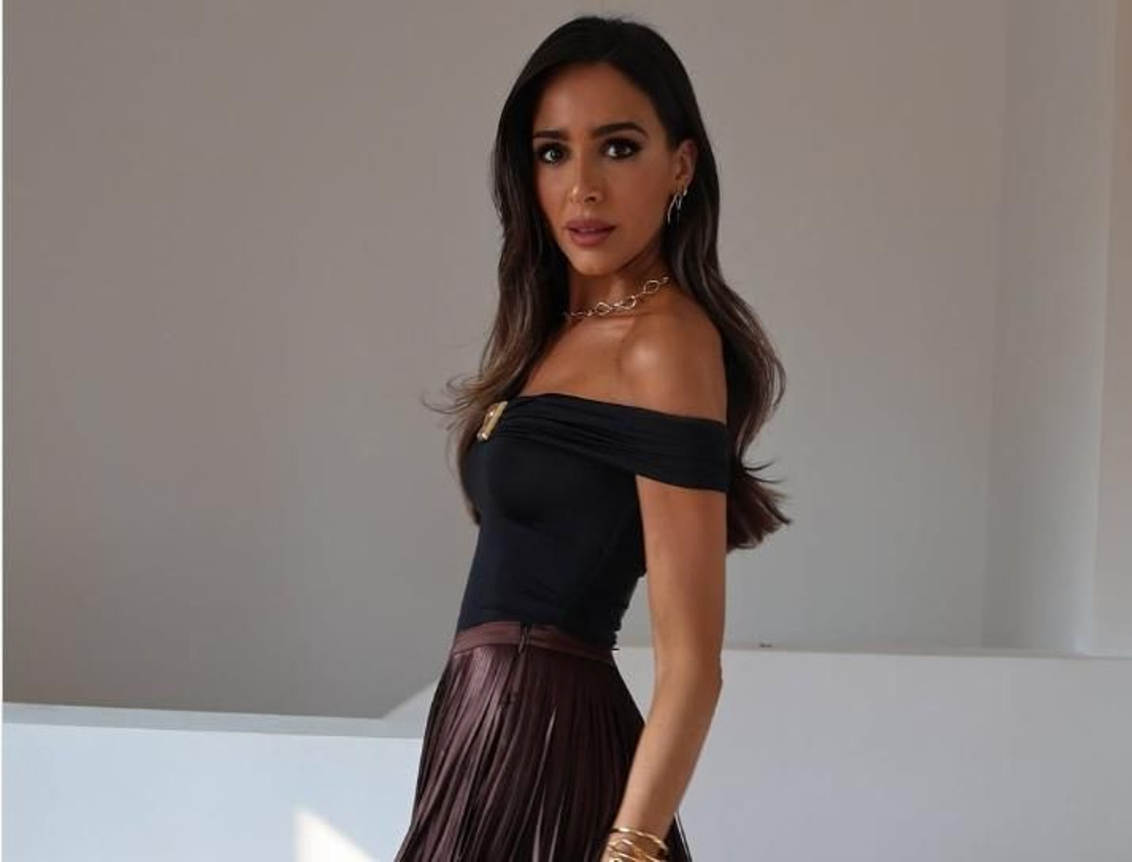 Rocío Osorno combina una falda de flecos marrón con un top negro con escote Bardot.