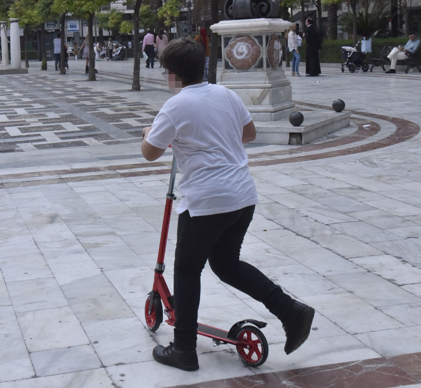 Un niño jugando con un patinete.