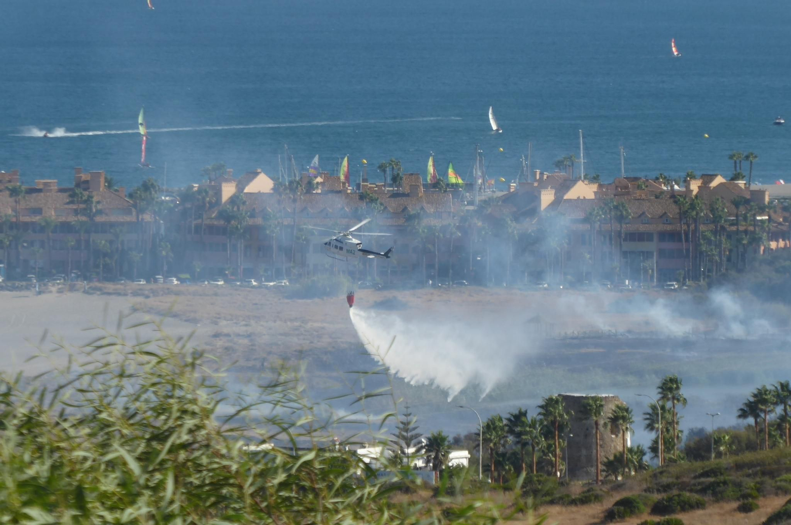 Un helicóptero del Infoca descarga agua sobre el fuego.