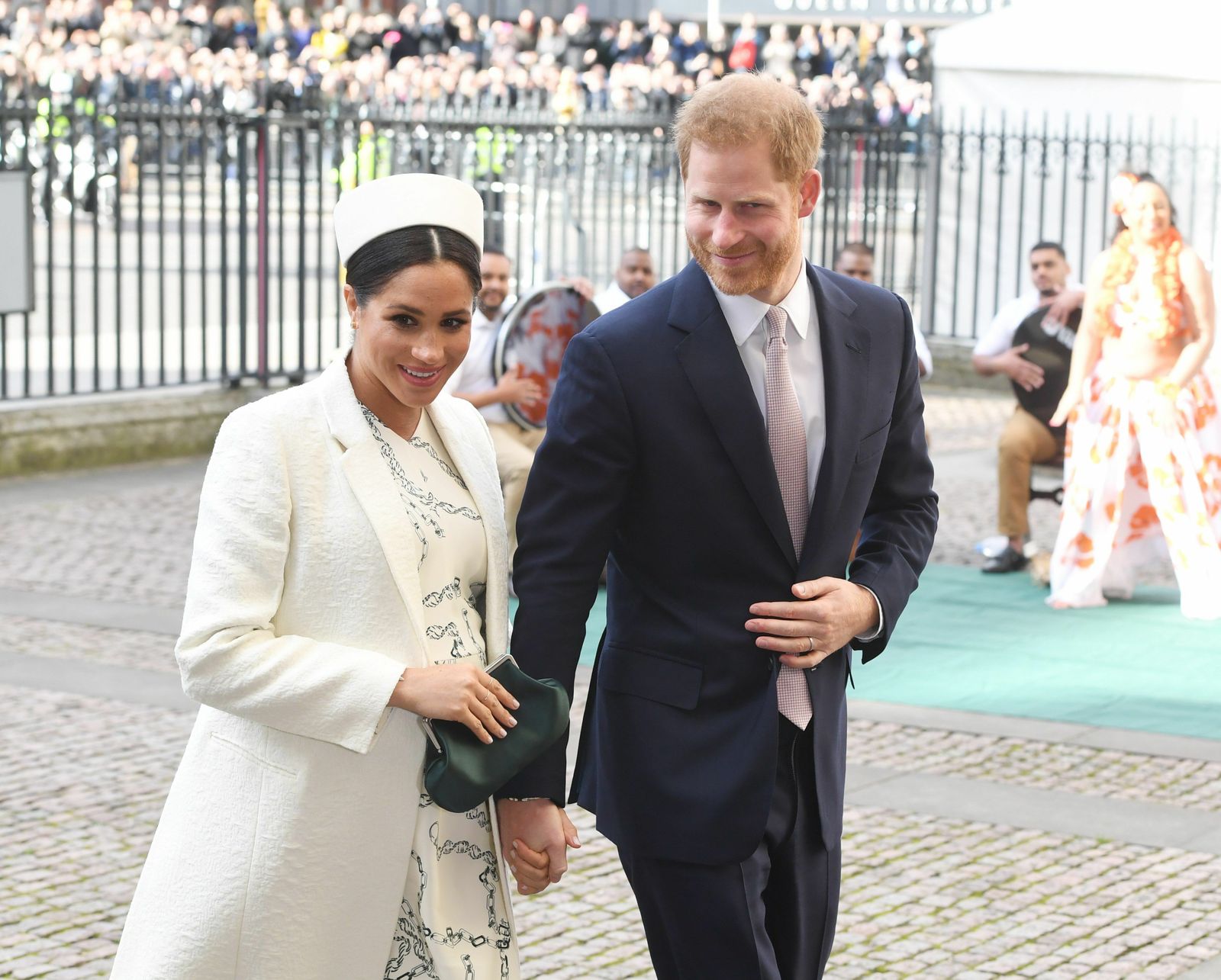 Meghan, con vestido de Victoria Beckham y abrigo blanco, junto a Enrique a su llegada a la Abadía de Westminster.