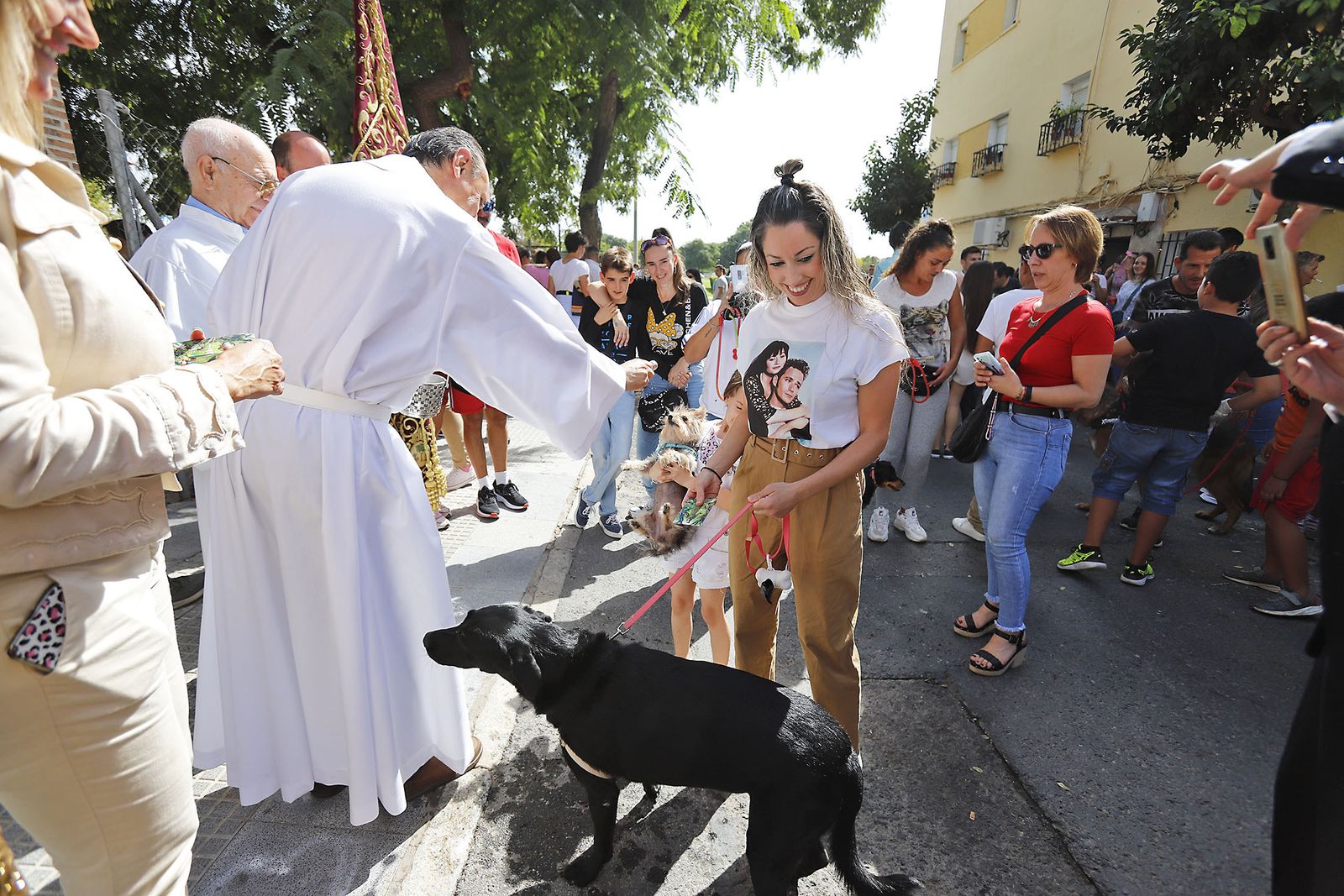 El sacerdote bendice un perro en el barrio onubense de Pérez Cubillas.